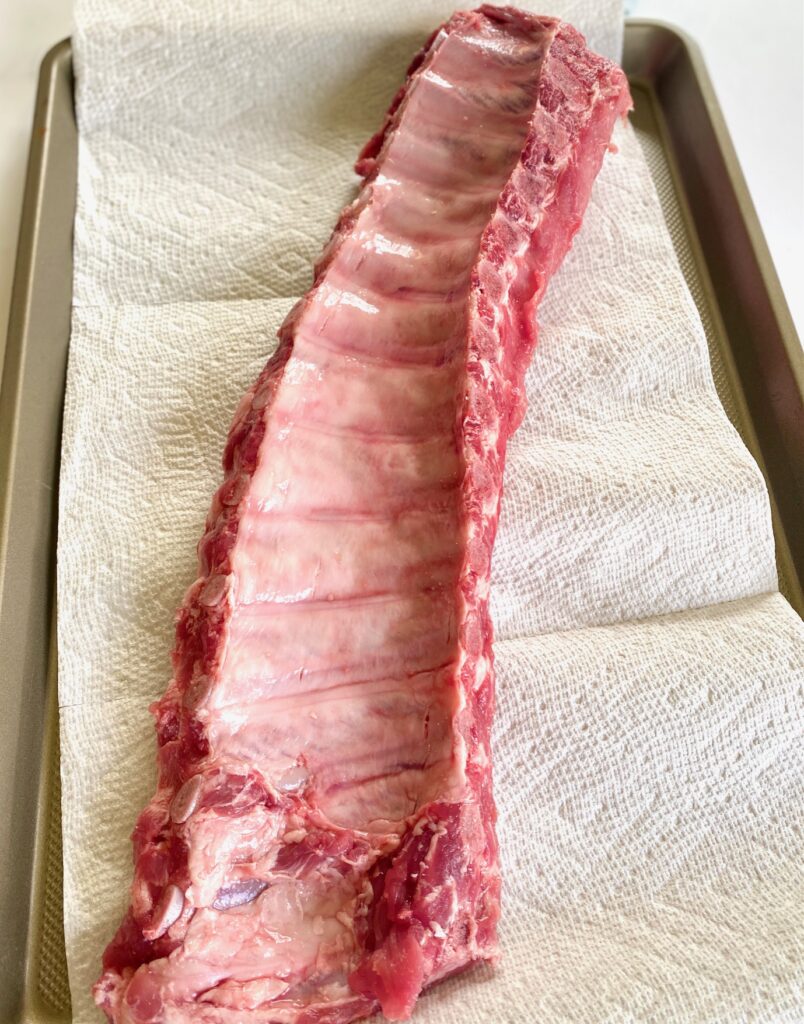 uncooked baby back ribs on a tray